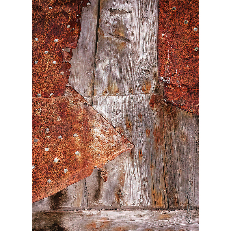 Gros plan sur un assemblage de bois ancien grisé et de plaques métalliques fortement rouillées fixées par des rivets, œuvre photographique de Pierre Tomy Le Boucher.