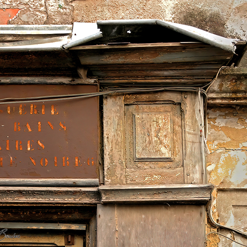 Détail d’une ancienne façade très altérée composée de bois, métal, peinture écaillée, câbles et moulures, œuvre photographique de Pierre Tomy Le Boucher.