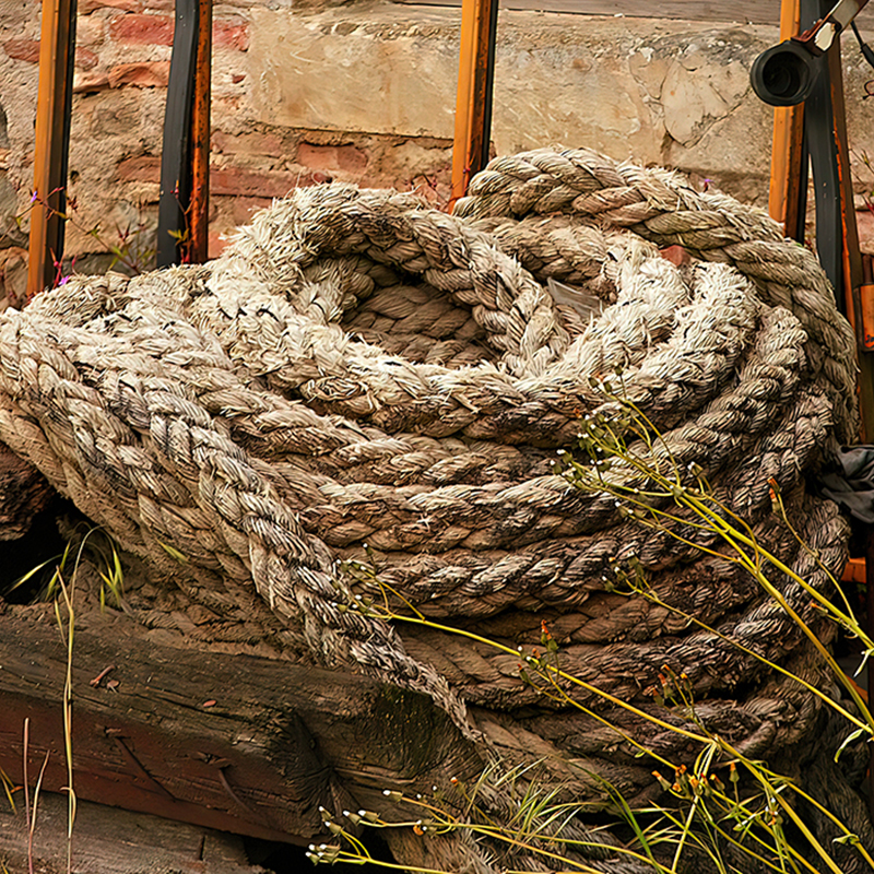 Ancienne corde épaisse, enroulée et fortement usée, dont les fibres sont effilochées et marquées par le temps, œuvre photographique de Pierre Tomy Le Boucher.