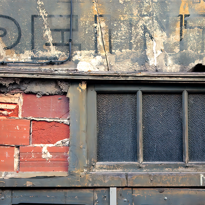 Détail d’une façade ancienne associant briques rouges, enduits gris et beige, peinture écaillée, inscriptions et châssis vitré, œuvre photographique de Pierre Tomy Le Boucher.