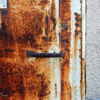 Porte métallique avec l'apparition des stigmates du temps et de l'usage.