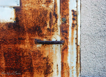 Porte métallique avec l'apparition des stigmates du temps et de l'usage.