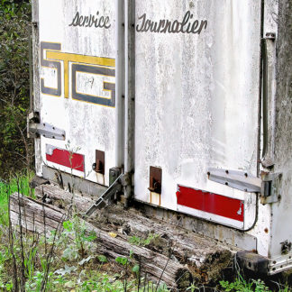 Détail de l'arrière d'un camion de l'entreprise STG avec l'apparition des stigmates du temps et de l'usage.