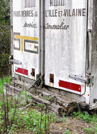 Détail de l'arrière d'un camion de l'entreprise STG avec l'apparition des stigmates du temps et de l'usage.